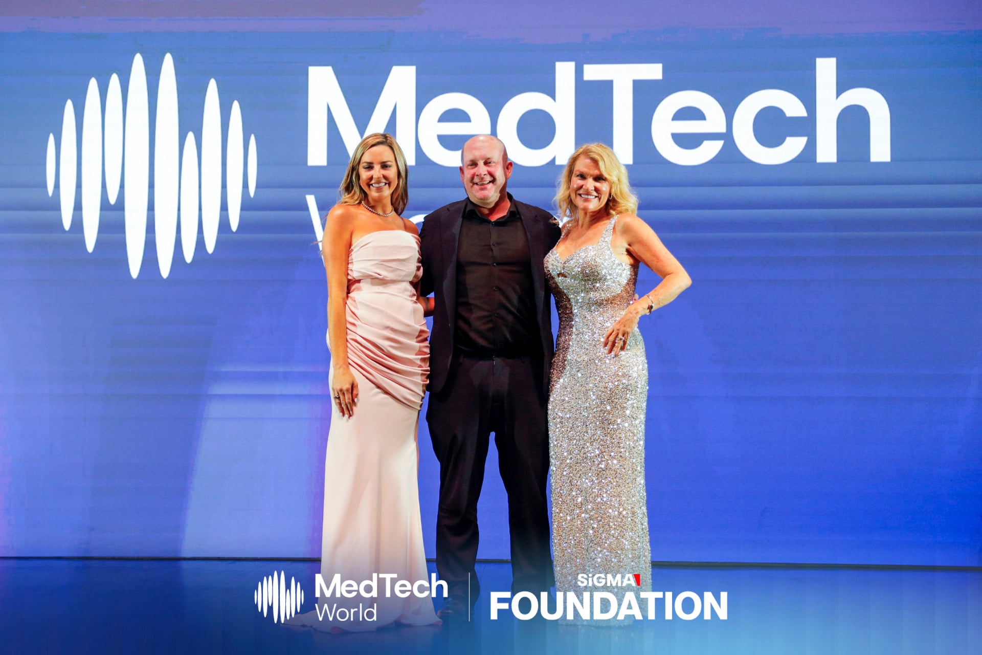 Melissa Espinosa on stage with award hosts at the MedTech World Awards in Hong Kong