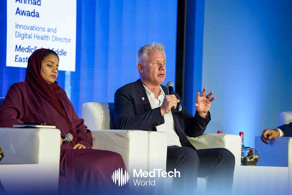Christian Espinosa speaking into a microphone on a seated panel at MedTech World Middle East