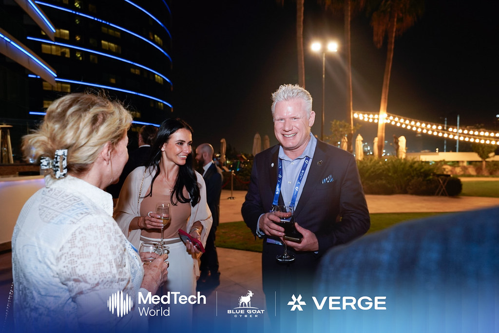 Christian Espinosa chatting with guests at an outdoor evening reception hosted with Verge and MedTech World