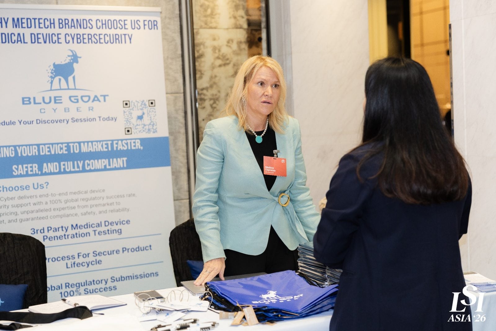 Melissa Espinosa speaking with an attendee at the Blue Goat Cyber booth at LSI Asia '26