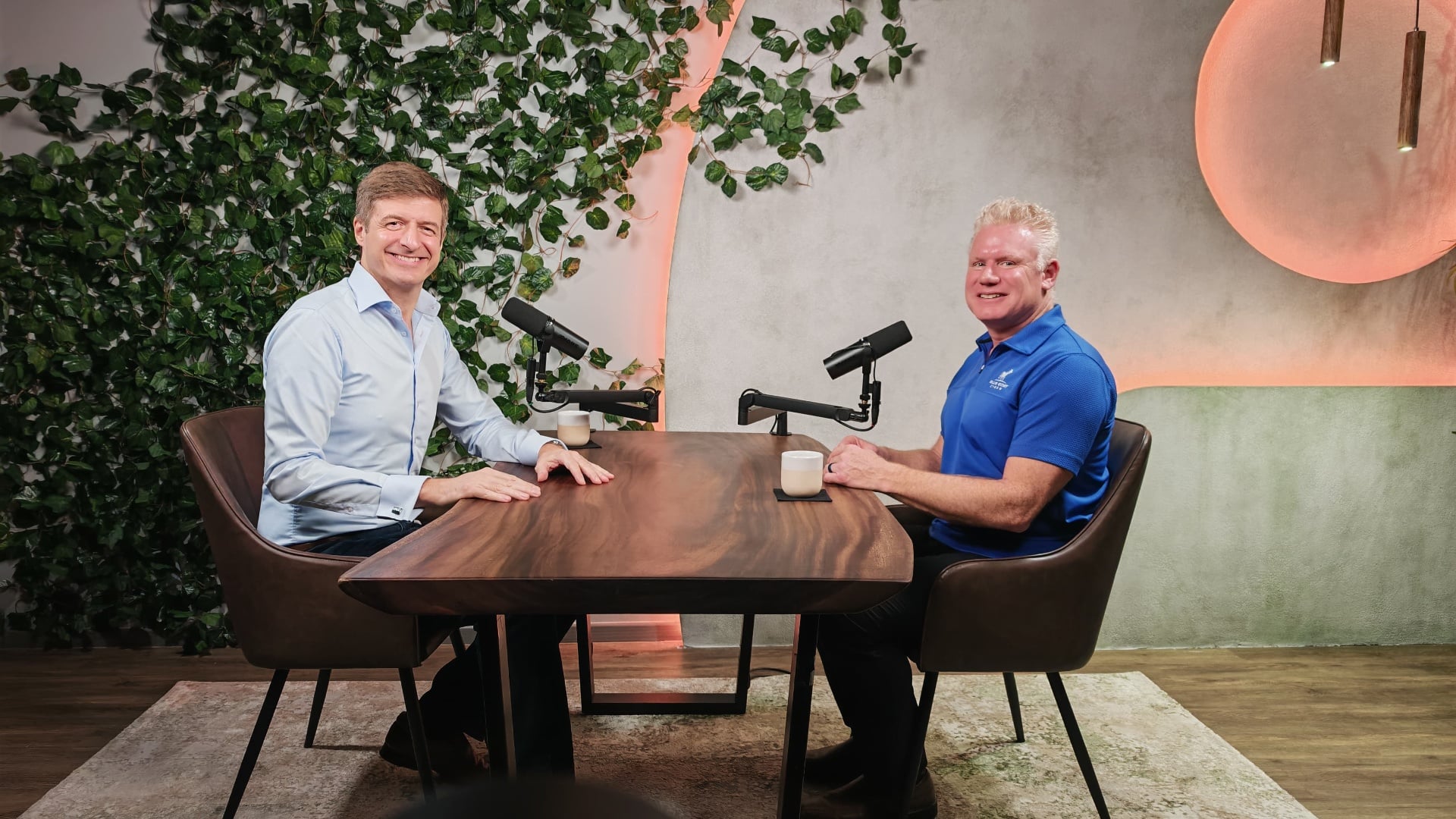 Christian Espinosa seated at a microphone across from a host, recording a medical device cybersecurity podcast interview in a Singapore studio