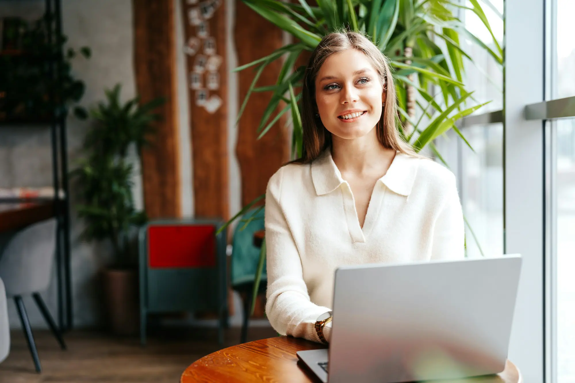 Young Professional Woman Working on Her Laptop at a Modern Cafe During Daytime