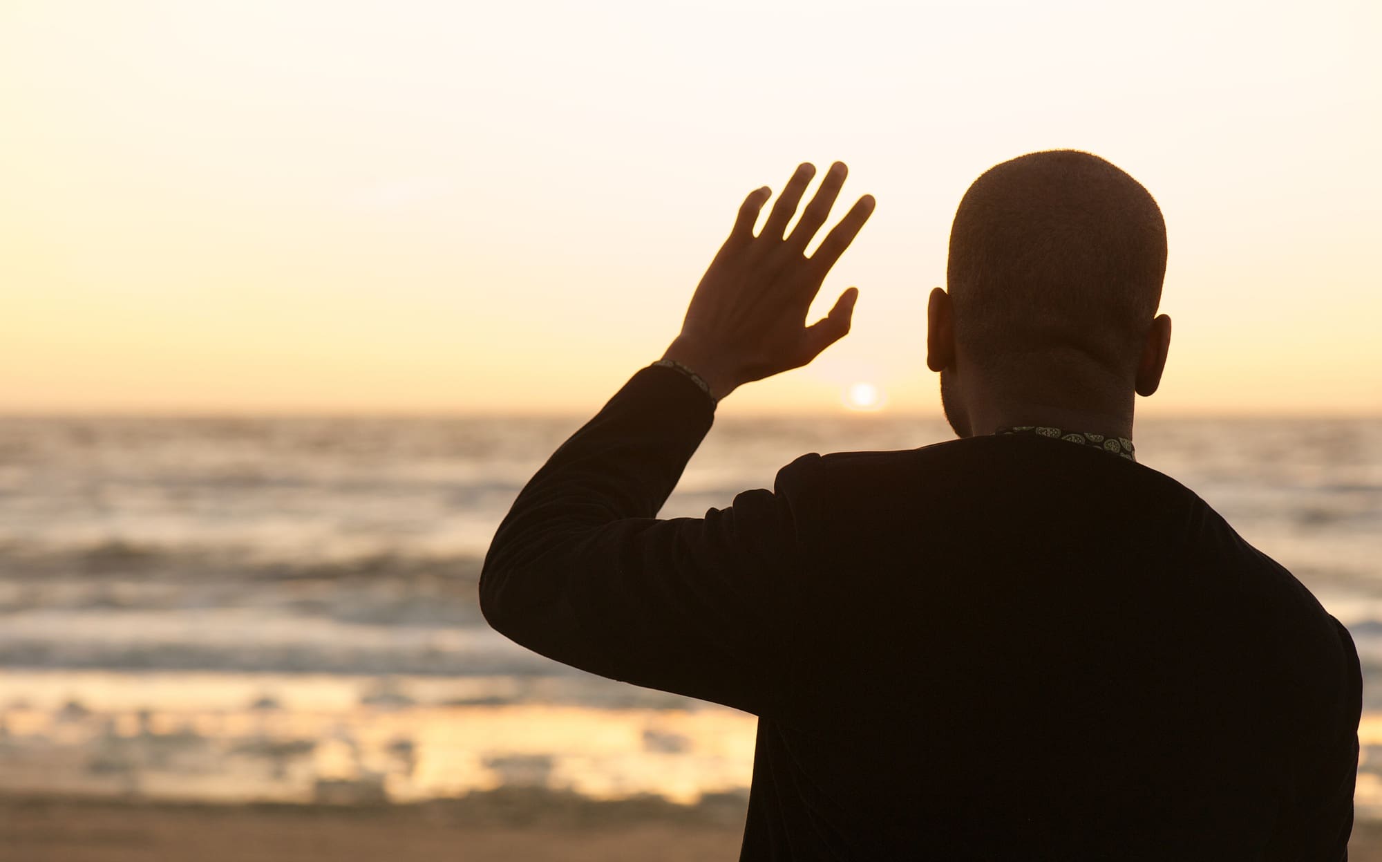 Man waving at the sunset